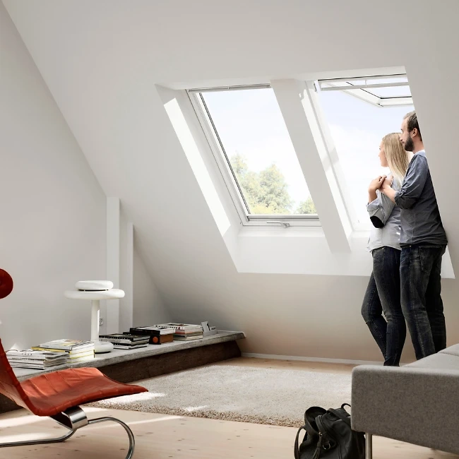 Paar steht am Dachfenster