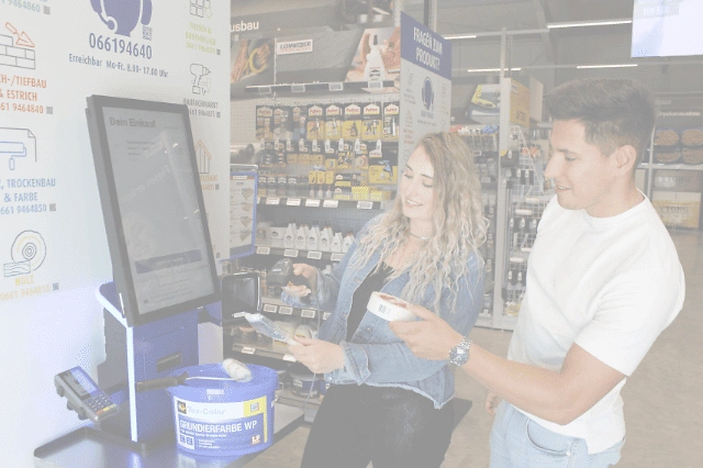 2 Personen scannen Ware am Self-Scan Terminal